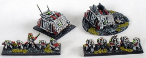 Sin Eater Command Squad and Rhino transport plus Sin Eater Terminator Squad with Terminator Chaplain. The wrecked Rhino on the right is an objective marker