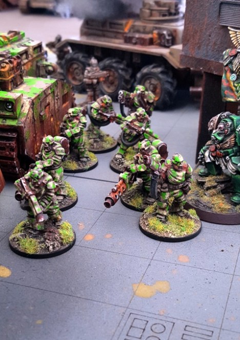 The armoured Imperial Guard dismount from their damaged transport.